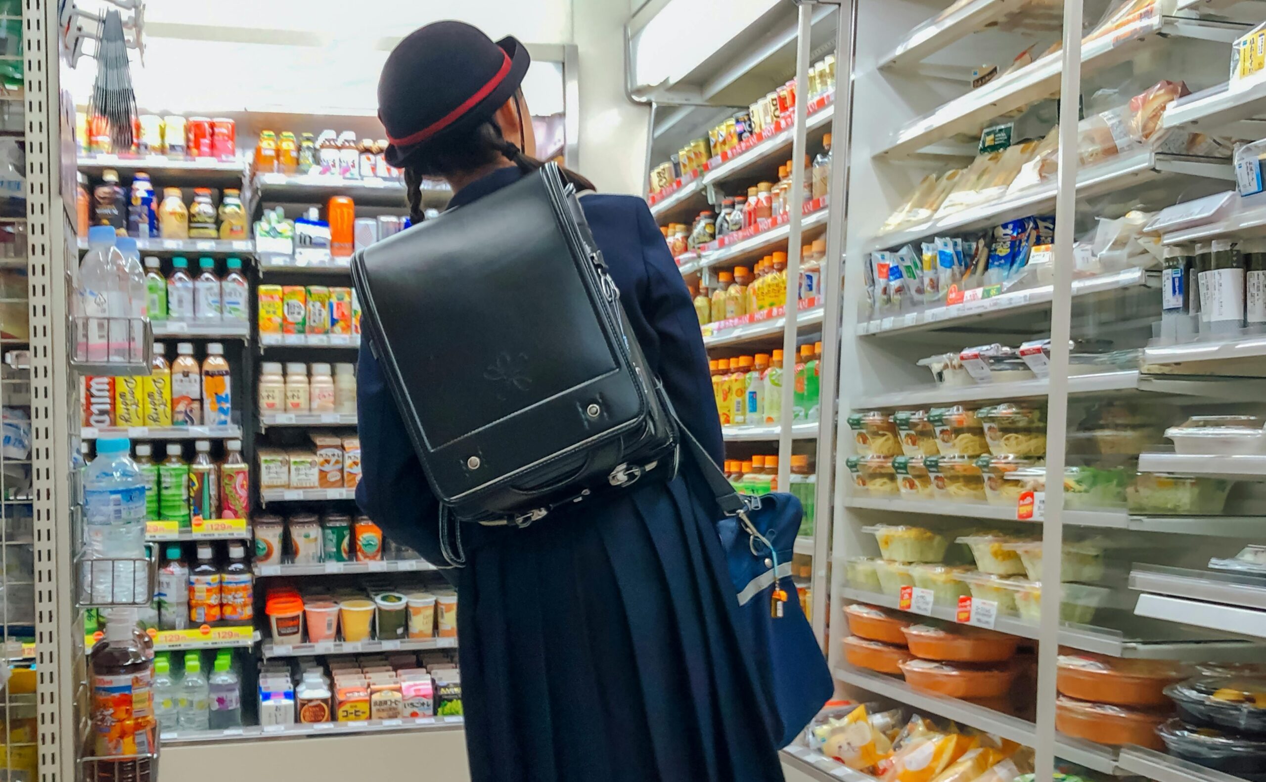 School girl checking out a food section of convenience store